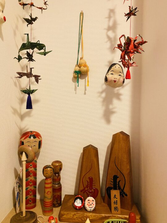 お多福、こけしやダルマ、手作り瓢箪が並ぶ和風な玄関の飾り棚の様子